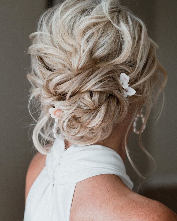 Messy Blonde Updo with White Floral Accents