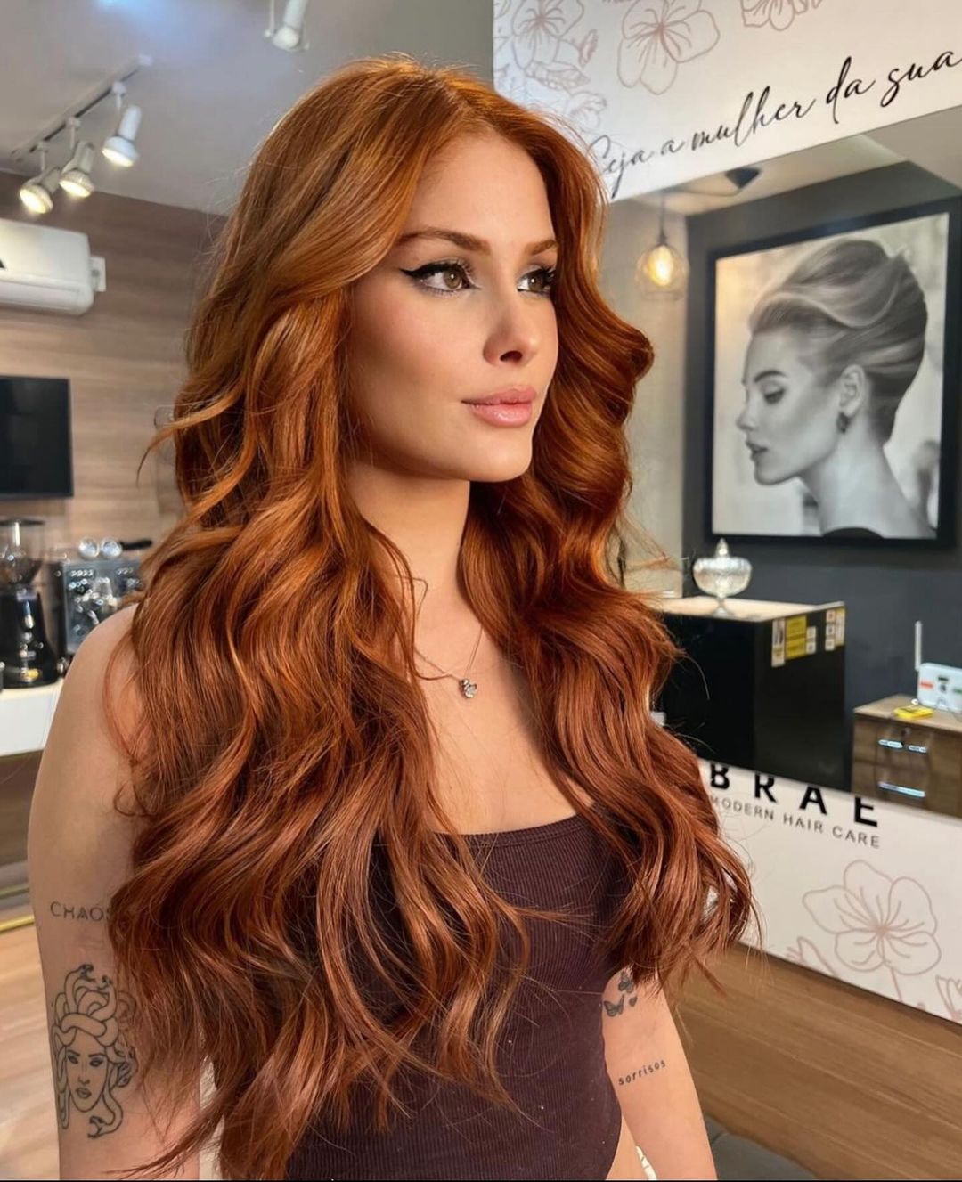 A woman with luscious copper-red hair styled in soft waves
