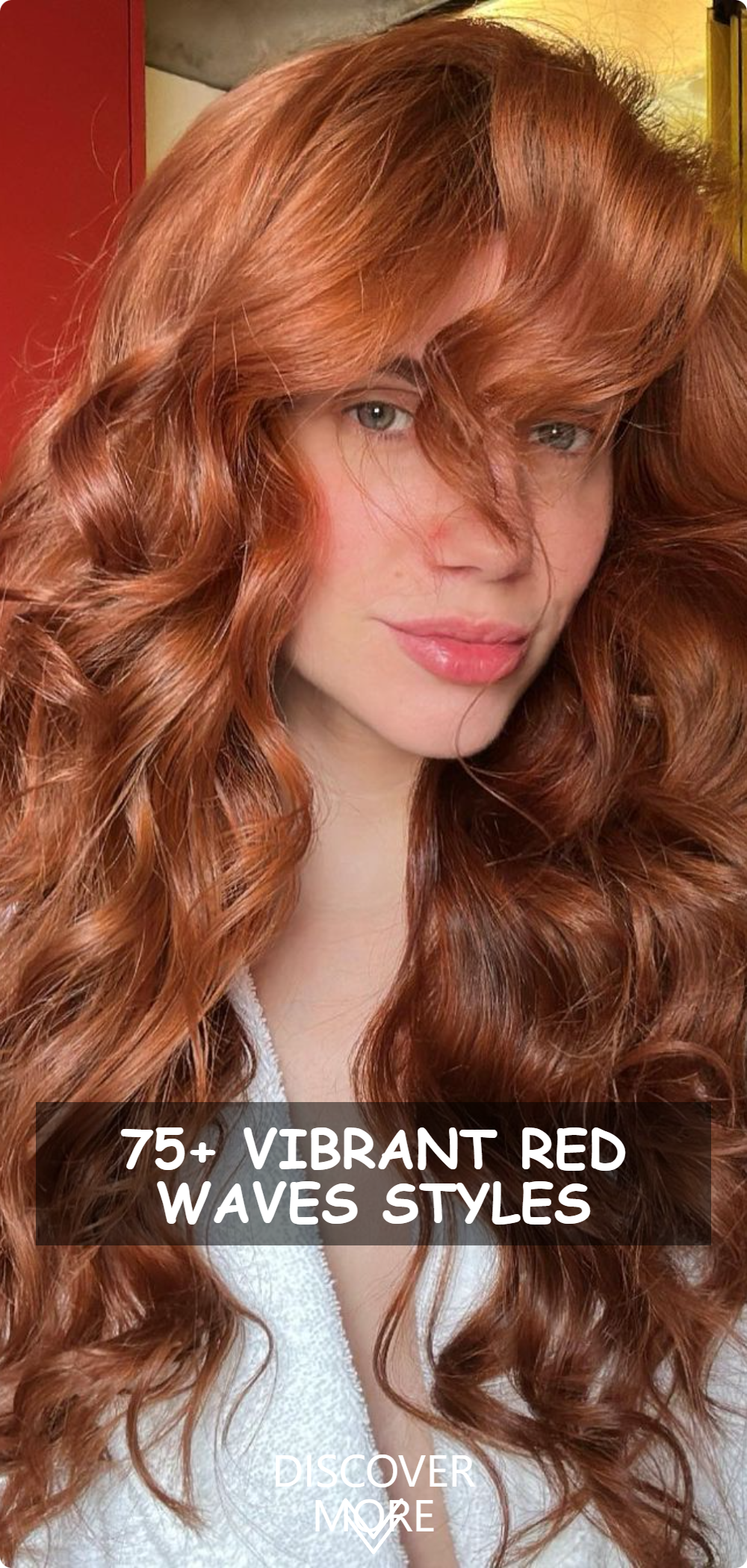 A woman with vibrant red wavy hair posing for a selfie