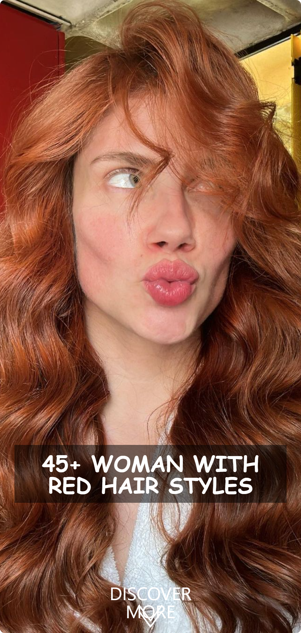 A woman with luscious red hair puckering for a playful selfie